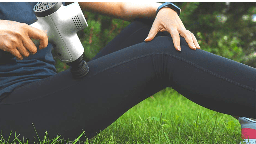 girl using massage gun after workout