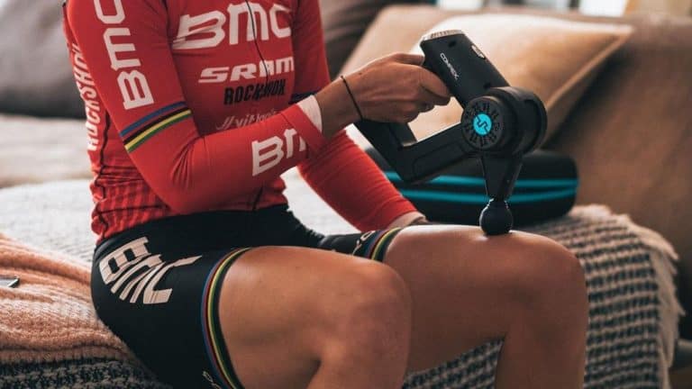 cyclist massaging his leg with a hand massager
