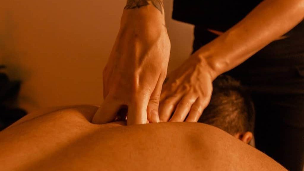 the masseur does a deep massage in the spine area