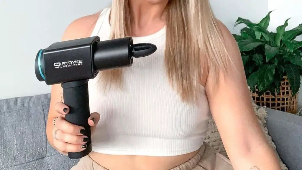 girl holding a massage gun in her right hand