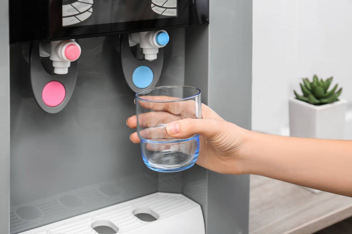 woman filling glass from water dispenser