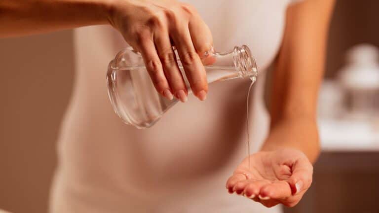 woman pouring massage oil into her hand