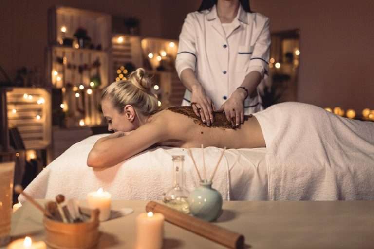 Candlelit massage room with a client on the table