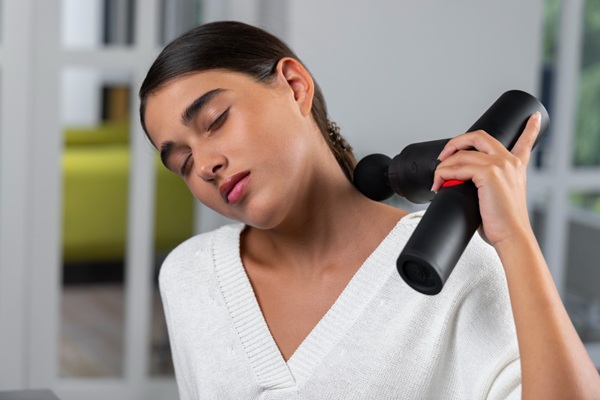 How to Massage Your Own Back 6779 (1) How to Massage Your Own Back, woman performing self back massage with massage gun