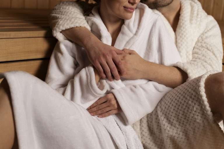 Hands giving a shoulder massage to a partner in a robe