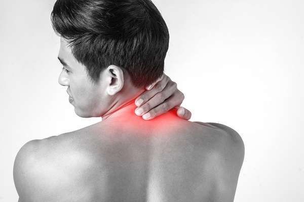 Muscular man use handles at the neck to relieve pain isolated on Can a Massage Help A Pinched Nerve: Get Relief Now!