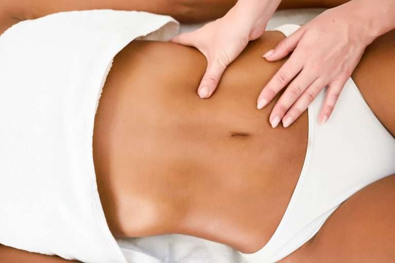 Hands resting gently on a woman's lower stomach
