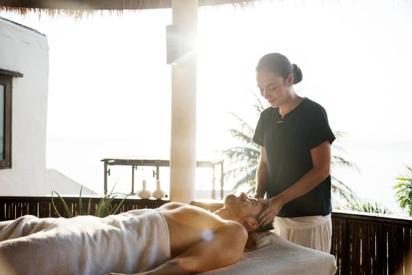 professional-massage-therapy-session Massage therapist performing a relaxing treatment on a client using a professional massage table