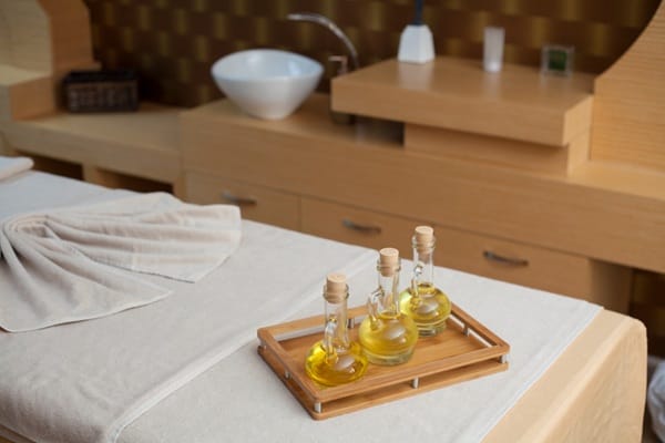 massage-table-oils-and-spa-setup Massage oils placed on a professional massage table in a relaxing spa room
