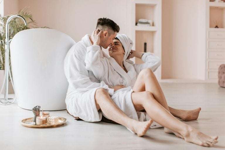 Couple in white robes relaxing together at home