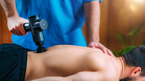 Why Use a Massage Gun for Lower Back Painherapist Massaging Man’s Lower Back Why Use a Massage Gun for Lower Back Pain