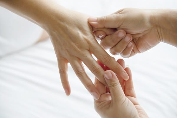 headache pressure points 28592 (1) woman receiving a Li4 massage hand pressure point