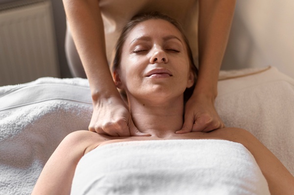 therapist performing gentle lymphatic drainage massage on neck
