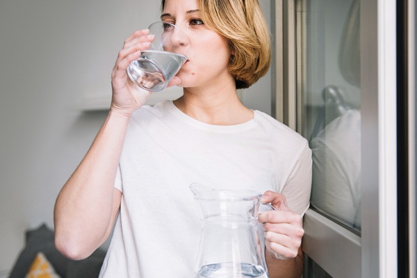 woman drinking water after massage to reduce side effects
