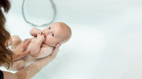 Warm Bath for Baby Constipation Comfort Parent supporting a baby during a warm bath