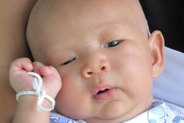 A young baby lying awake and alert with clear, untroubled eyes